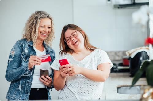 Duas mulheres conversando uma está com um cartão na mão e a outra com um celular demonstrando uma possível renegociação divida santander